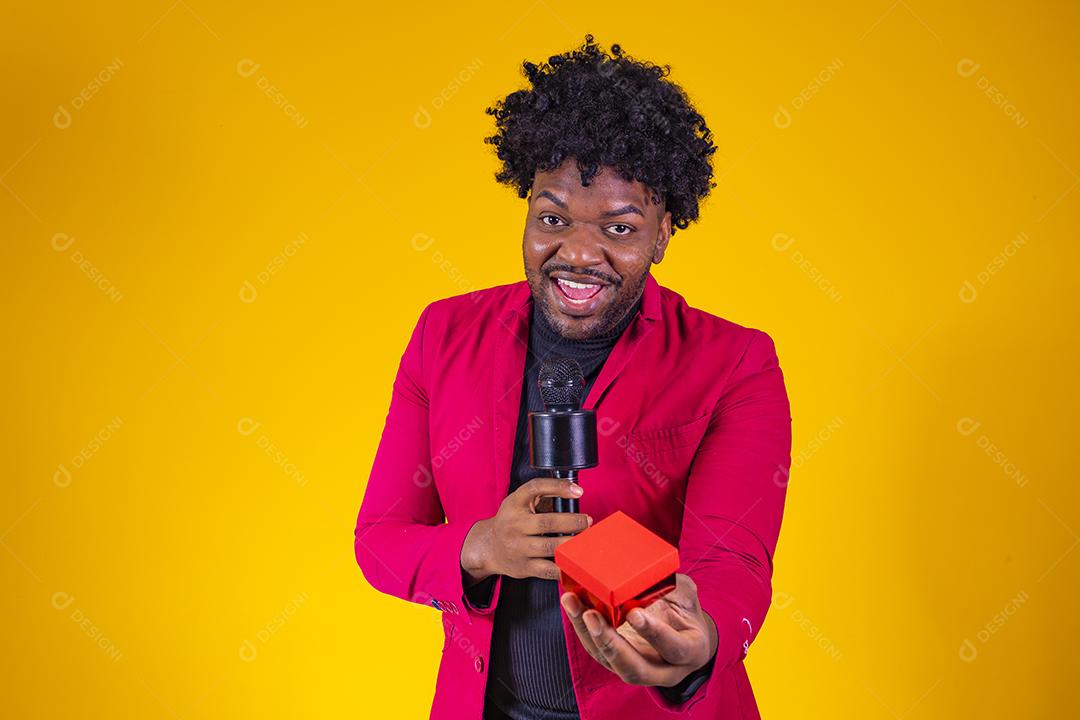 Homem moreno segurando estojo de veludo alianças