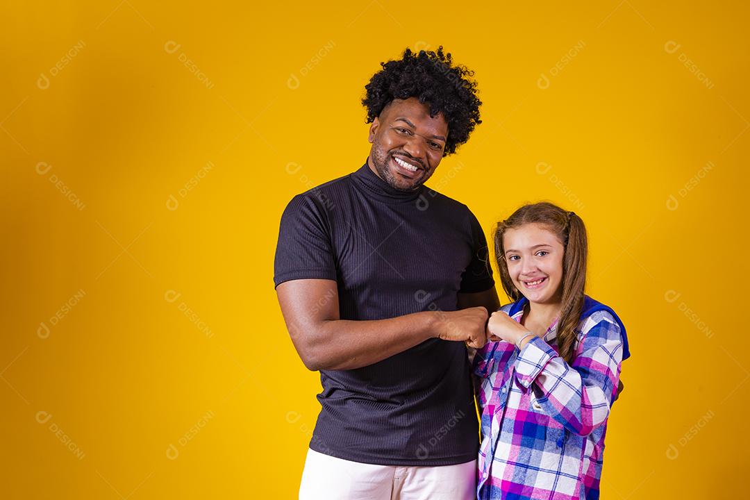 pai e filha em fundo amarelo comemorando a vitória. Pai e filha fazendo sinal de sim