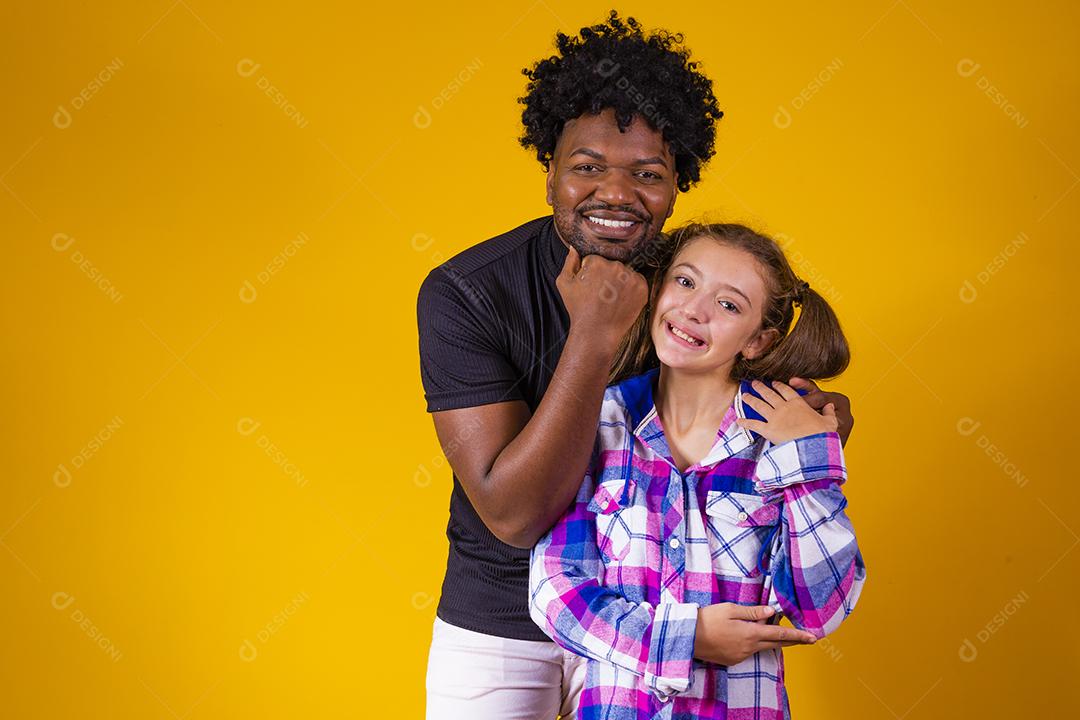 pai e filha em fundo amarelo comemorando a vitória. Pai e filha fazendo sinal de sim