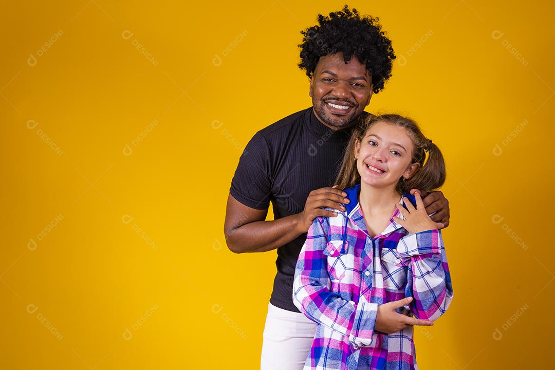 pai e filha em fundo amarelo comemorando a vitória. Pai e filha fazendo sinal de sim