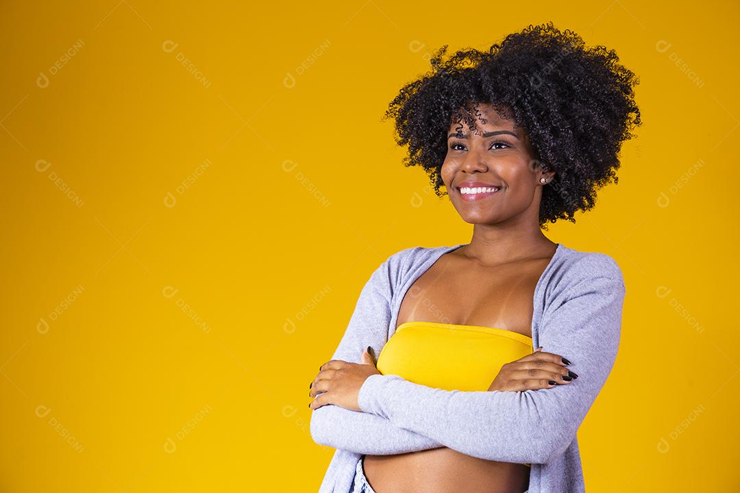 Linda mulher afro-americana olhando para a câmera Menina de beleza com cabelo encaracolado. Braços cruzados