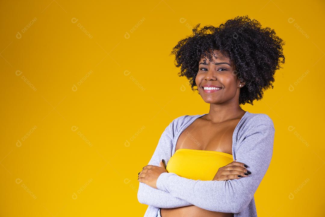 Linda mulher afro-americana olhando para a câmera Menina de beleza com cabelo encaracolado. Braços cruzados