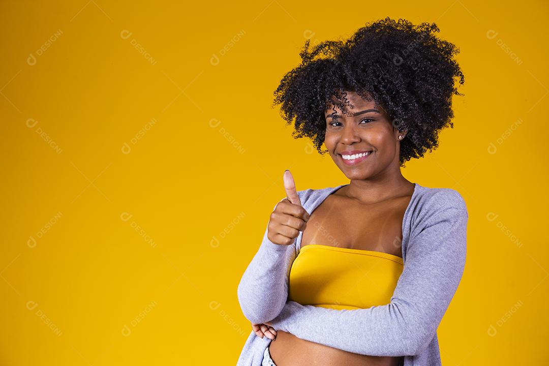 Linda mulher afro-americana olhando para a câmera Menina de beleza com cabelo encaracolado. Braços cruzados