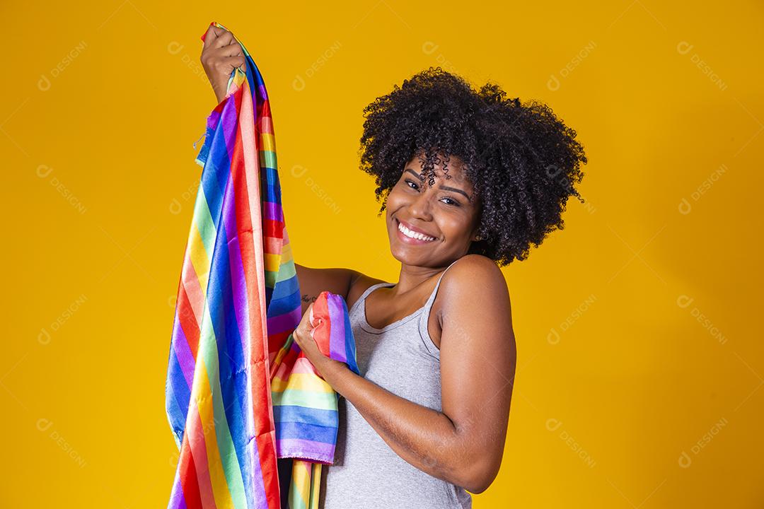 Jovem afro segurando nas mãos uma bandeira lgbt. orgulho gay