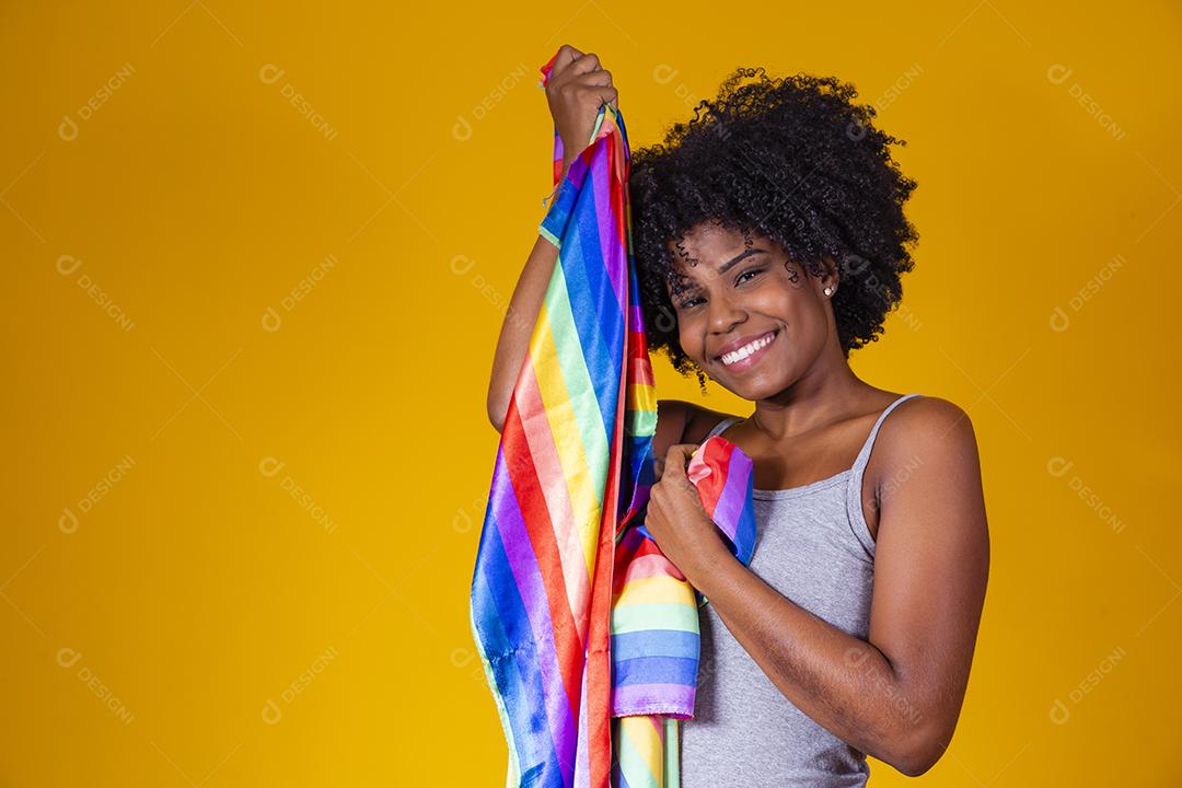 Jovem afro segurando nas mãos uma bandeira lgbt. orgulho gay