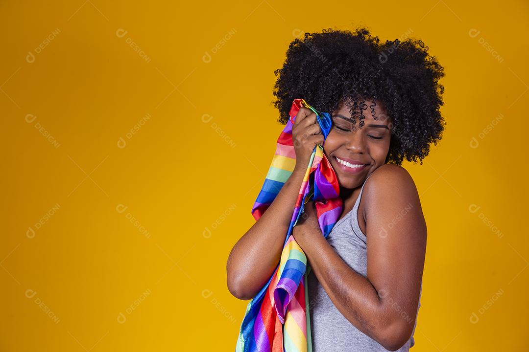 Jovem afro segurando nas mãos uma bandeira lgbt. orgulho gay