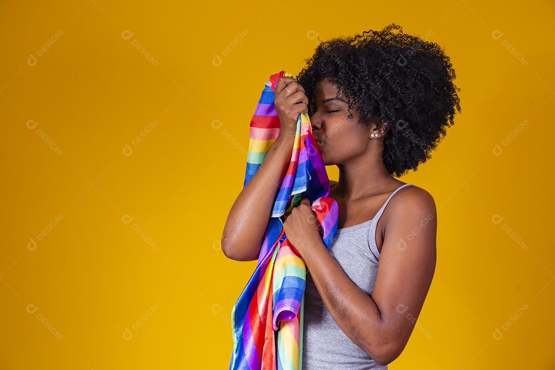 Jovem afro segurando nas mãos uma bandeira lgbt. orgulho gay
