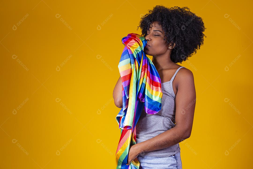 Jovem afro segurando nas mãos uma bandeira lgbt. orgulho gay