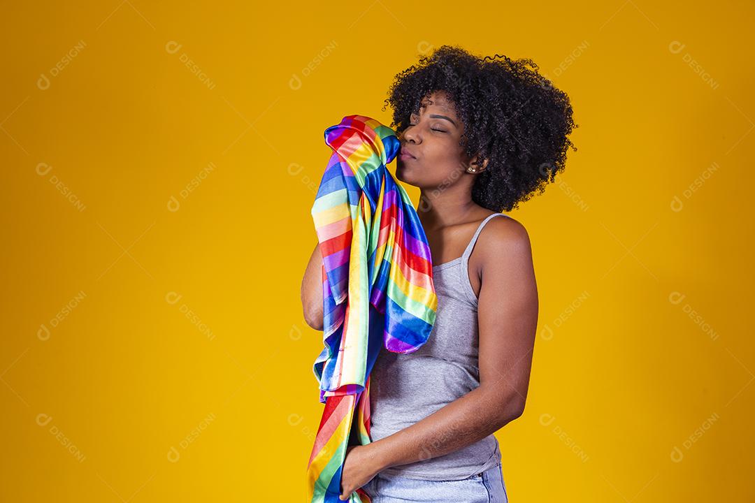 Jovem afro segurando nas mãos uma bandeira lgbt. orgulho gay