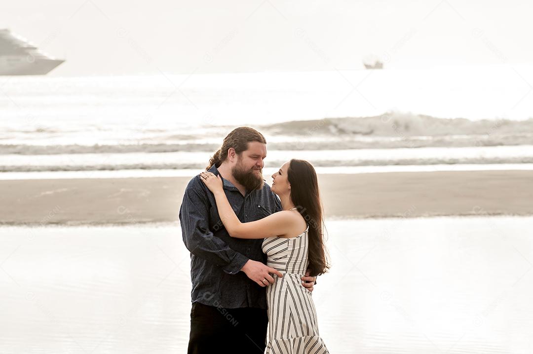 Casal apaixonado na praia ao nascer do sol