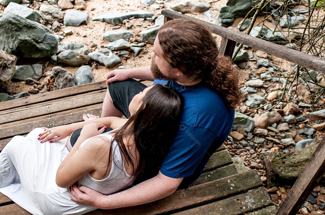 Casal apaixonado sentado na escada olhando para o mar