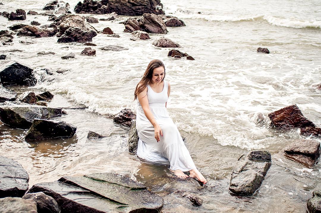 Garota feliz em vestido de noiva à beira-mar