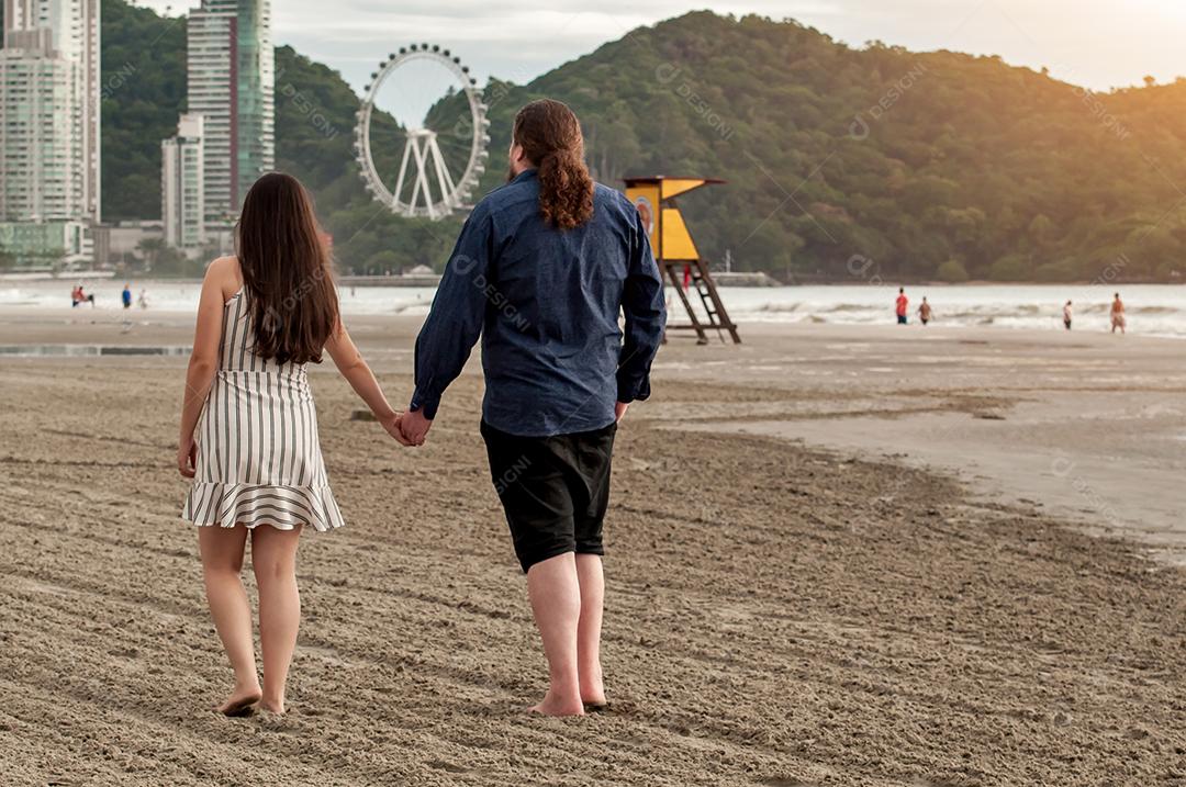 Casal apaixonado caminhando na praia em Balneário Camboriú-Brasil