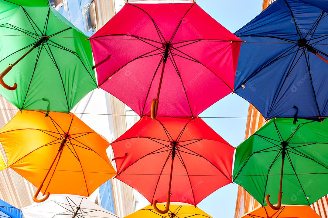 Rua com vários guarda-chuvas coloridos.