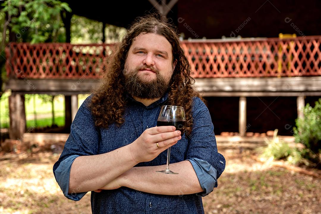 Homem barbudo segurando o copo de vinho, homem peludo loiro.