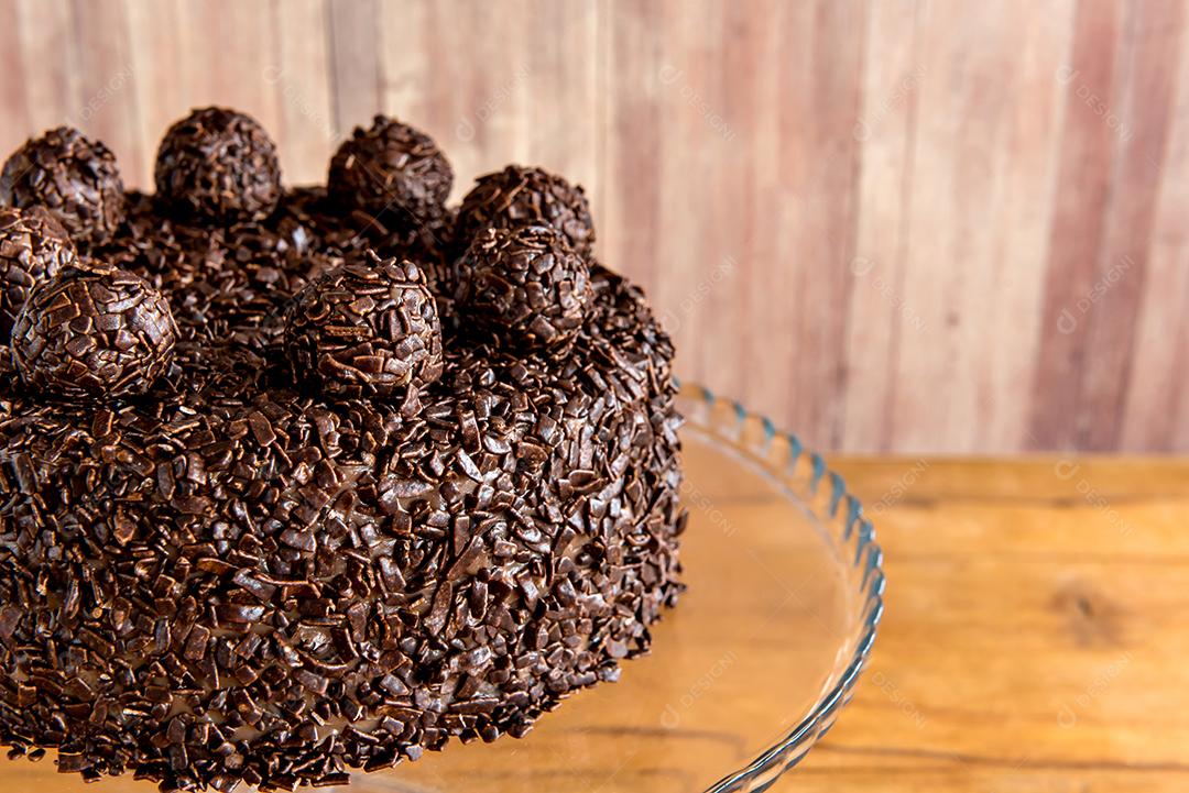 Bolo de chocolate com grãos de brigadeiro, deliciosa sobremesa em um fundo de madeira