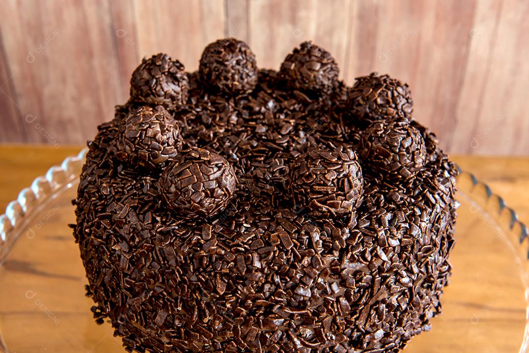 Bolo de chocolate com grãos de brigadeiro, deliciosa sobremesa em um fundo de madeira