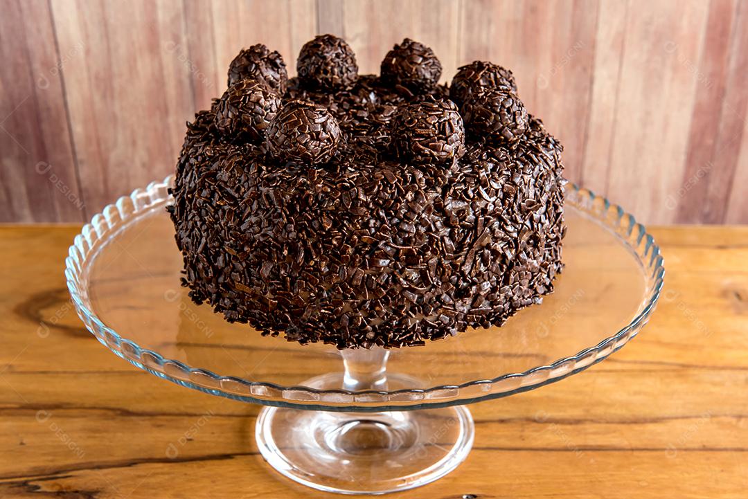 Bolo de chocolate com grãos de brigadeiro, deliciosa sobremesa em um fundo de madeira
