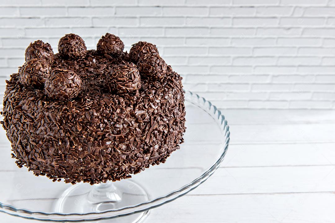 Bolo de chocolate com grãos de brigadeiro, deliciosa sobremesa em fundo branco