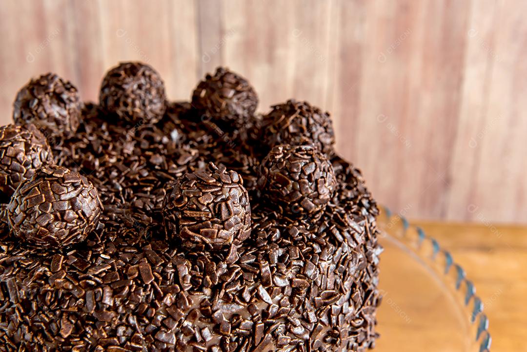 Bolo de chocolate com grãos de brigadeiro, deliciosa sobremesa em um fundo de madeira