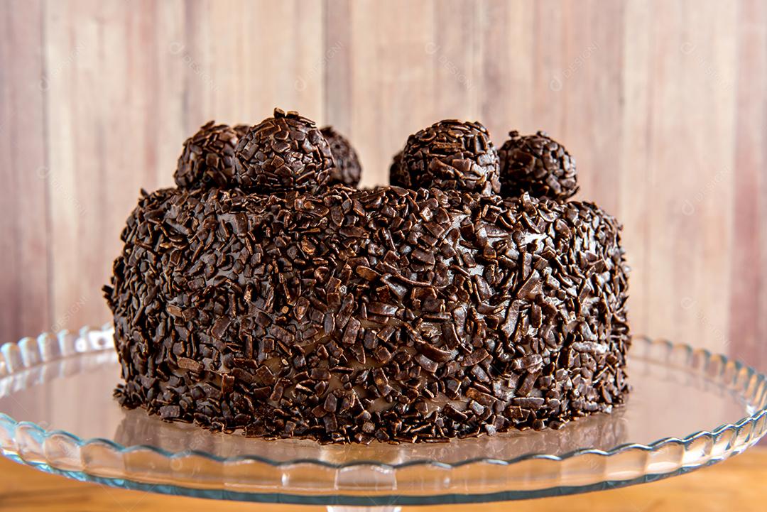 Bolo de chocolate com grãos de brigadeiro, deliciosa sobremesa em um fundo de madeira