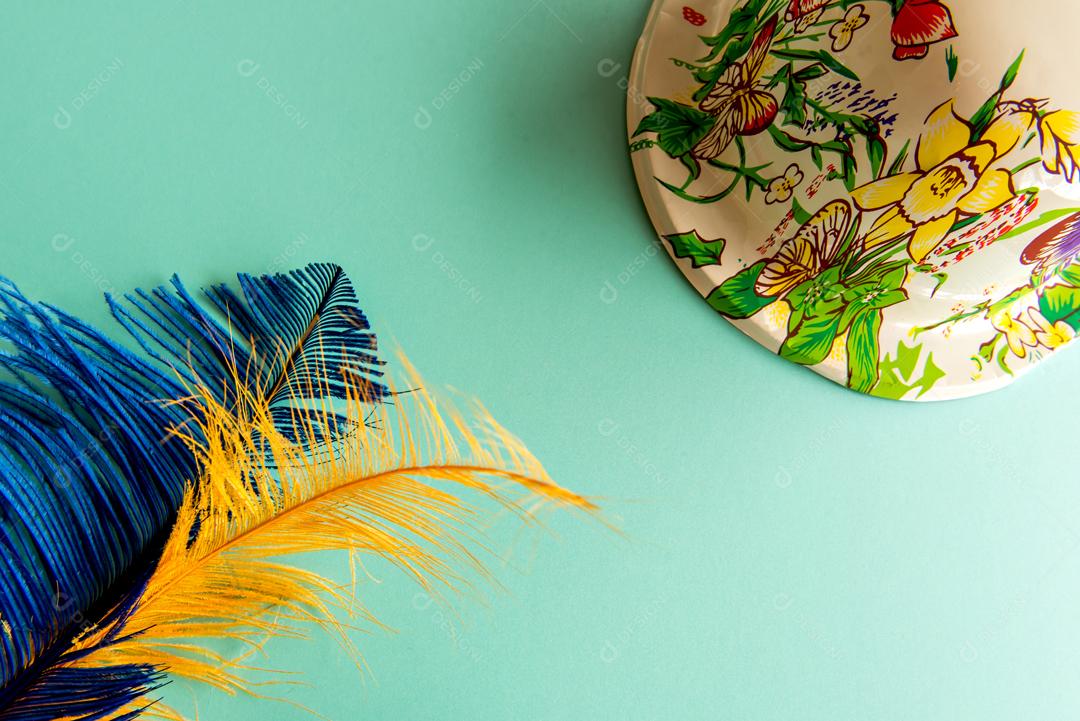 Chapéu de carnaval e penas coloridas sobre fundo verde carnaval brasileiro