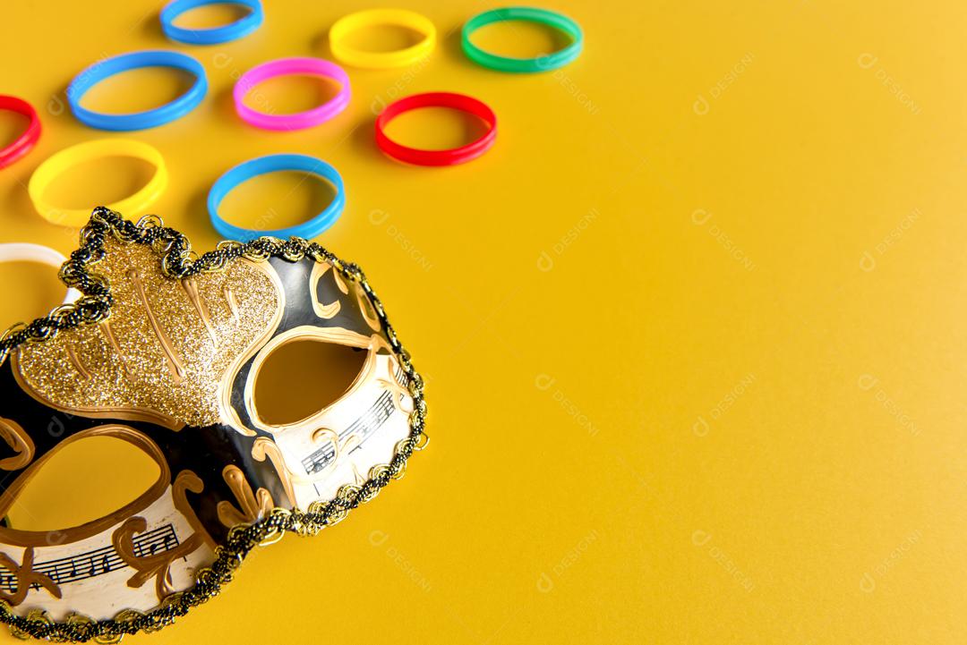 Máscara de carnaval Dourada sobre fundo Amarelo carnaval brasileiro