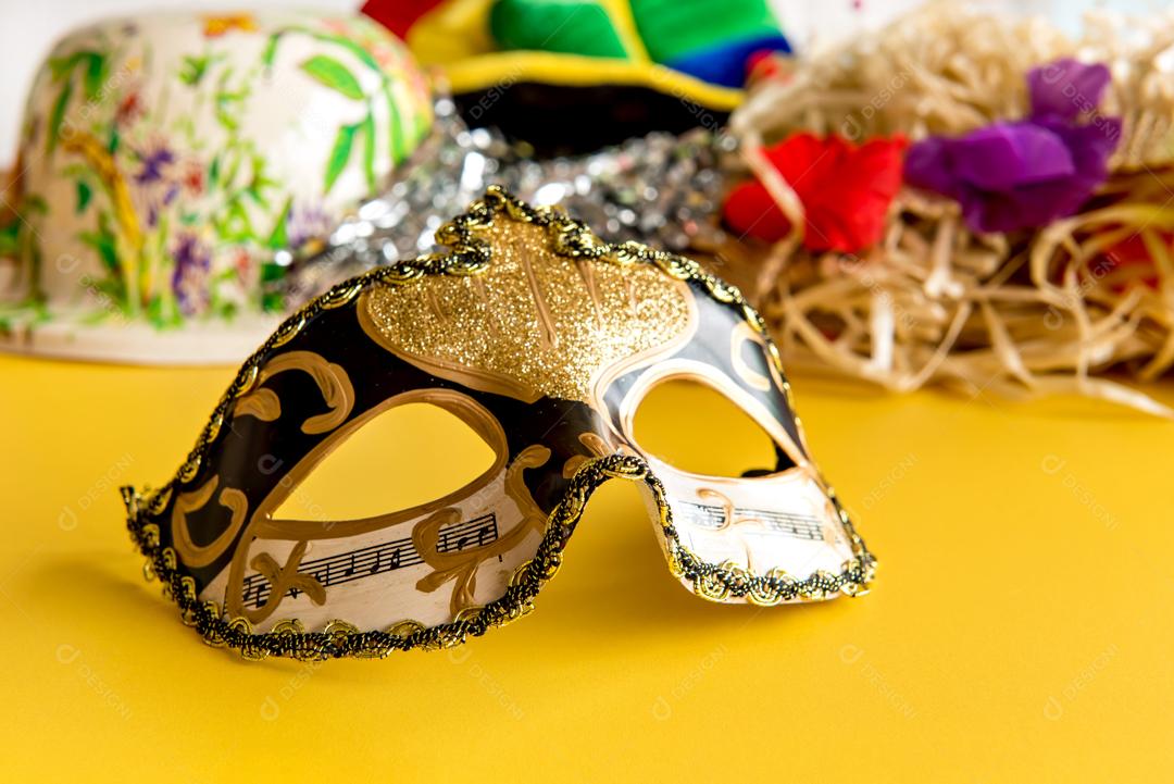Máscara de carnaval Dourada Penas e Chapéu sobre fundo Amarelo carnaval brasileiro