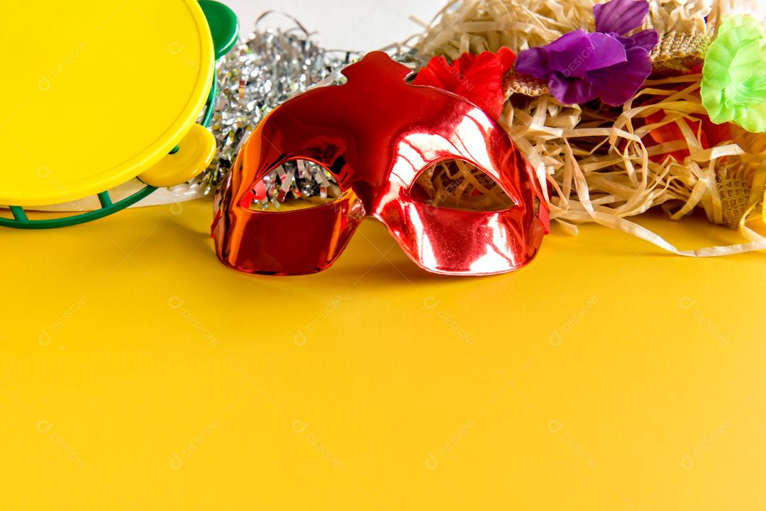 Máscara de carnaval Vermelha Pandeiro e palhas sobre fundo Amarelo carnaval brasileiro