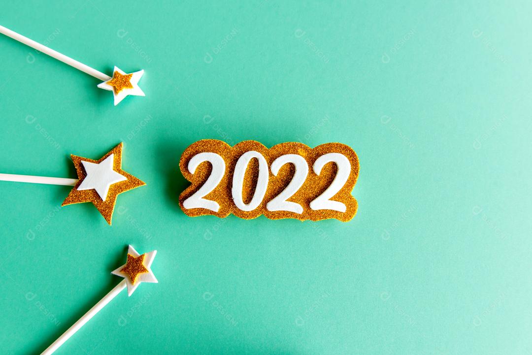 Fundo verde com papel EVA ano 2022 dourado e algumas estrelas feliz ano novo