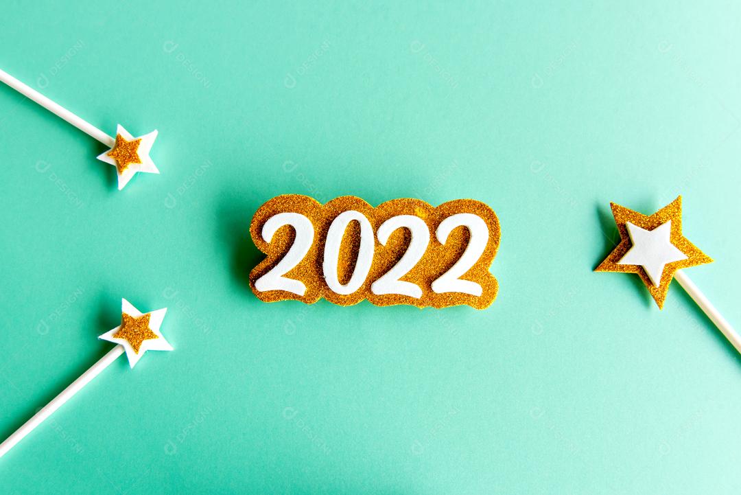 Fundo verde com papel EVA ano 2022 dourado e algumas estrelas feliz ano novo