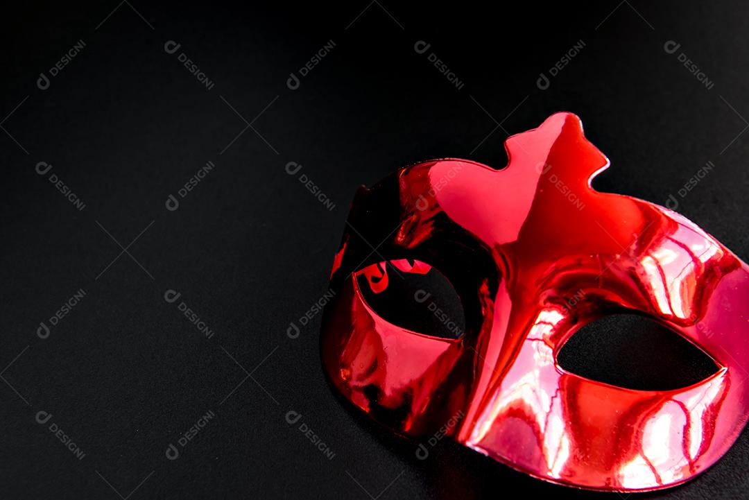 Conceito de carnaval brasileiro, máscara vermelha de carnaval em fundo preto