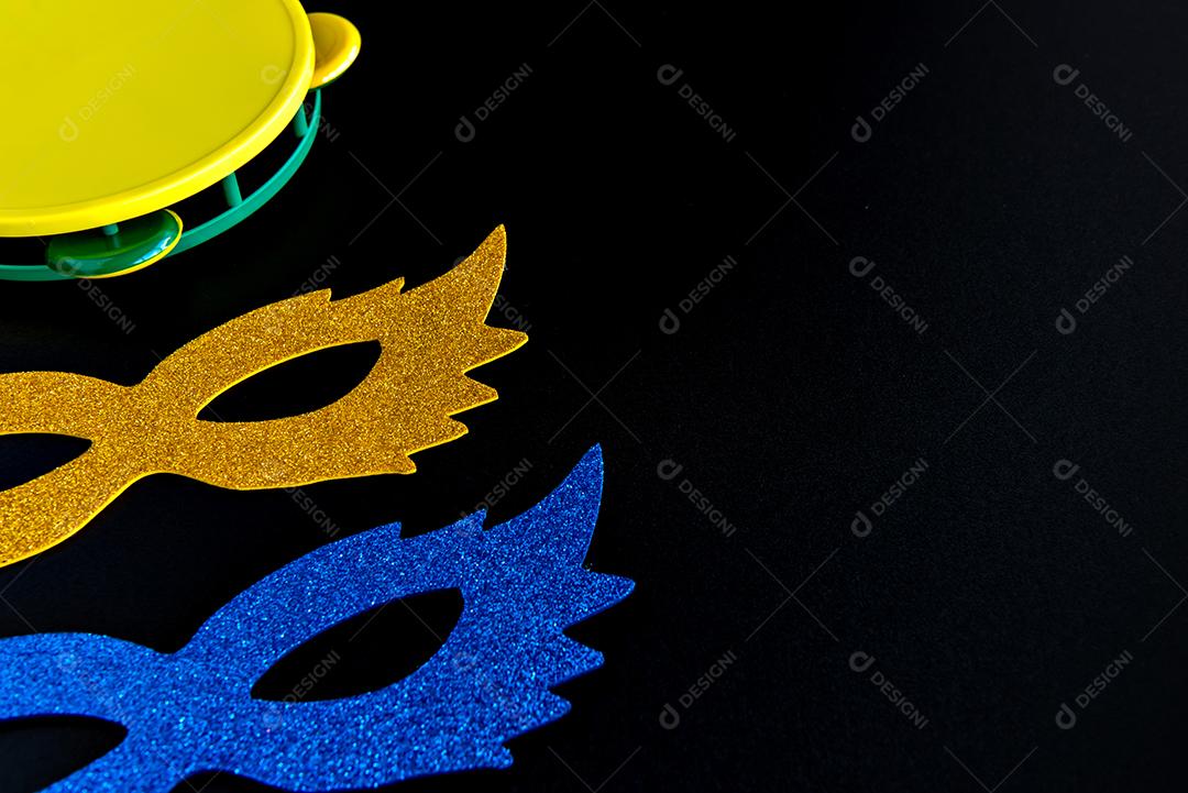 Brazilian carnival concept, carnival mask and tambourine on black background