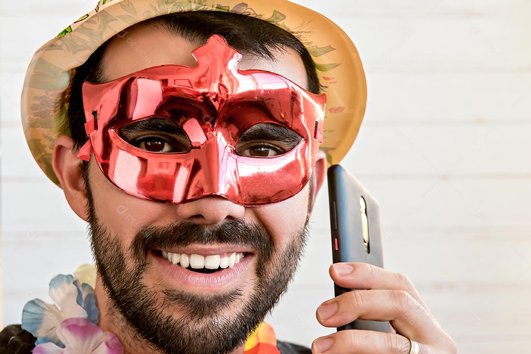 Homem vestido com fantasia de festa de carnaval fazendo um telefonema.