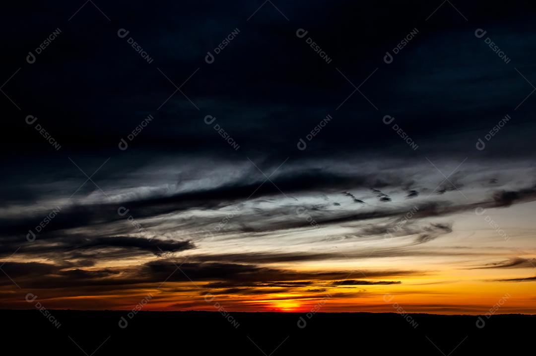 Crepúsculo, início da noite, pôr do sol laranja no campo.