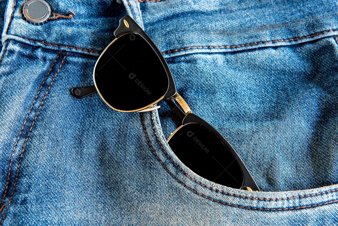 Calça jeans com óculos de sol no bolso