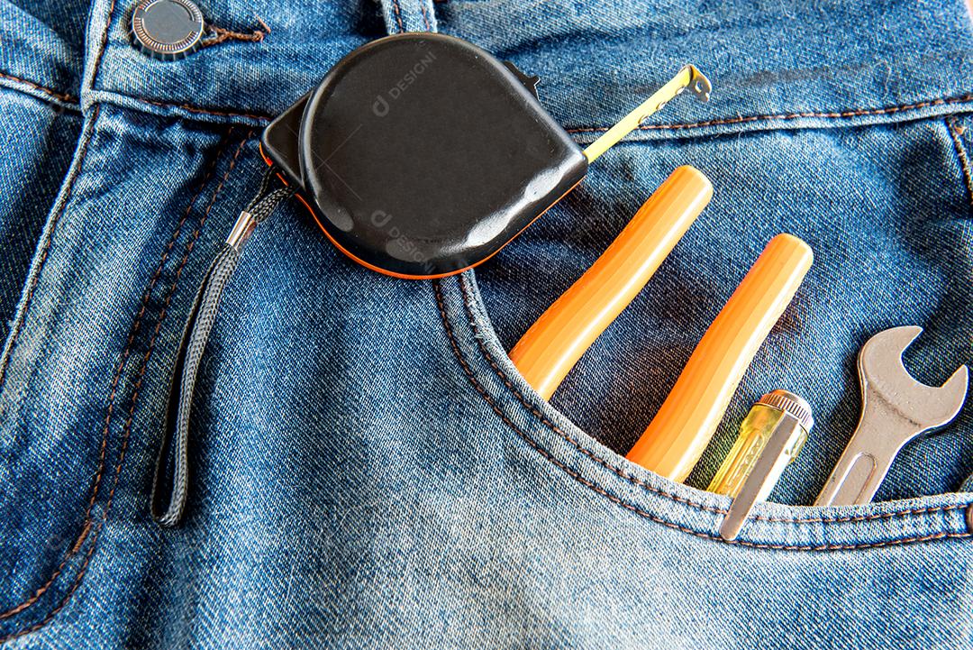 Calça jeans com trena e ferramentas de trabalho no bolso