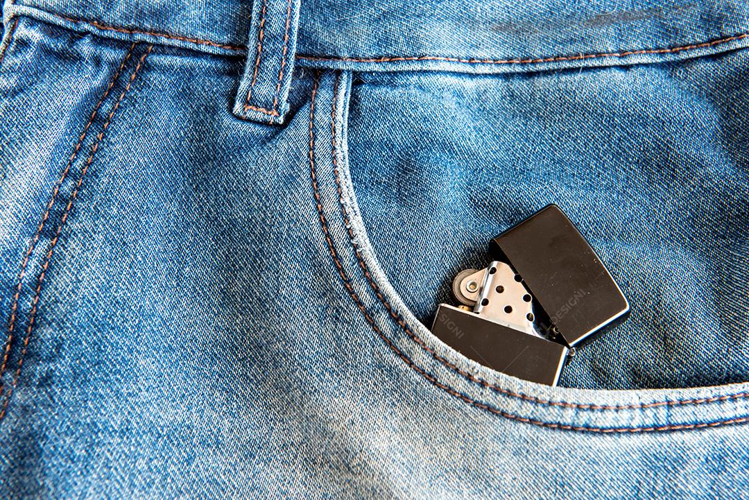 Isqueiro preto no bolso da calça jeans.