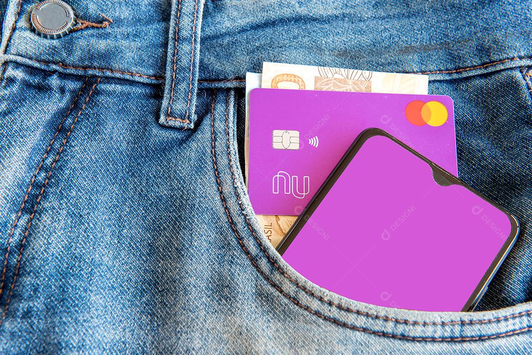 Calça jeans com celular e cartão de crédito no bolso