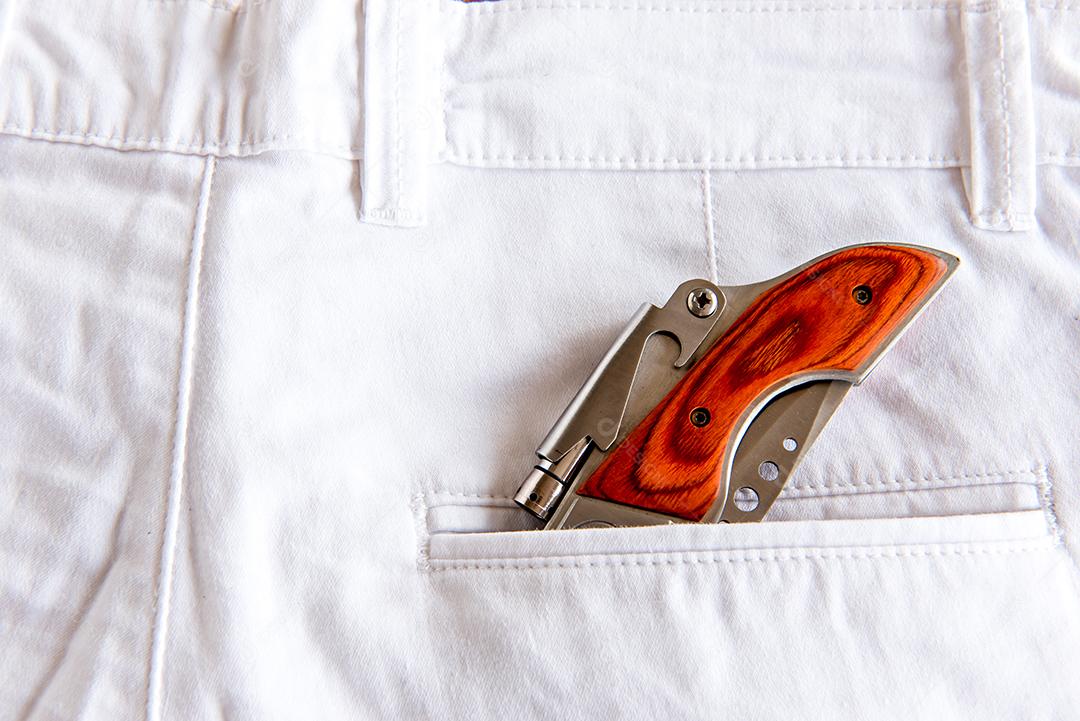 Calça jeans com canivete no bolso