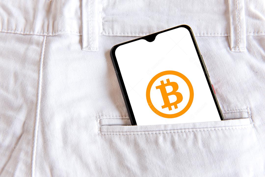 Calça jeans com celular com tela aberta de bitcoin no bolso