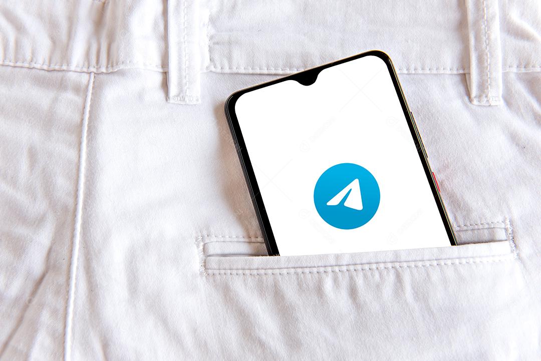 Smartphone com aplicativo de telegrama no bolso da calça jeans branca
