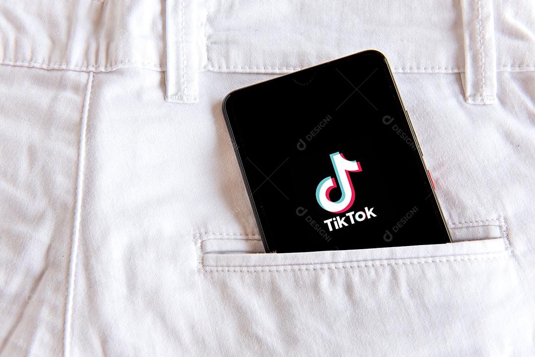 Calça jeans com celular com tela aberta de tiktok  no bolso