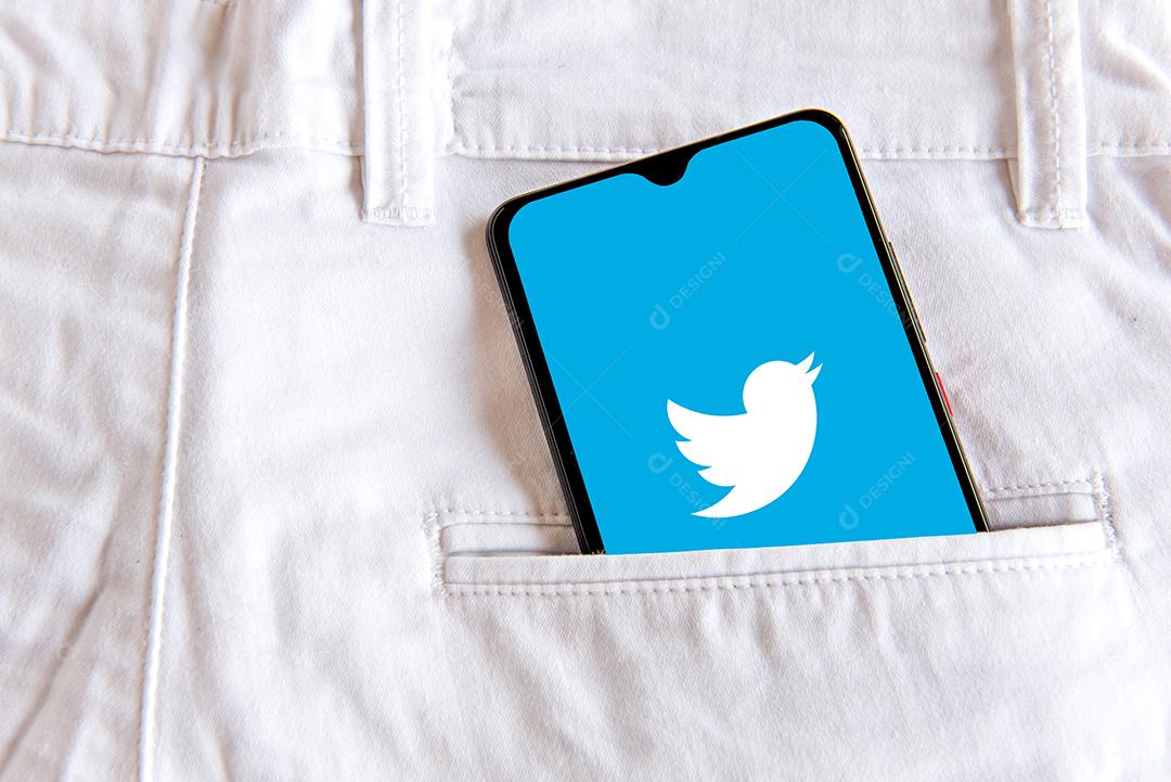 Smartphone with twitter application in the pocket of white jeans.