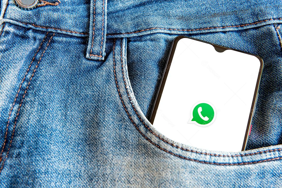 Smartphone com aplicativo whatsapp no ​​bolso da calça jeans.