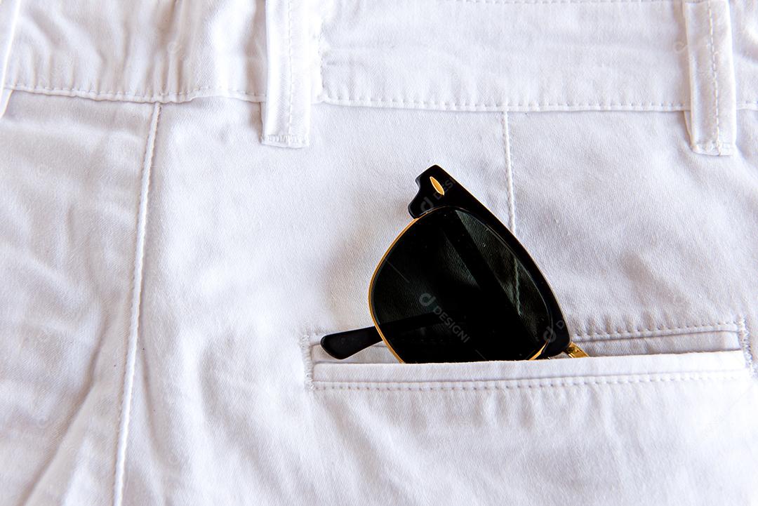 Calça jeans com óculos de sol no bolso