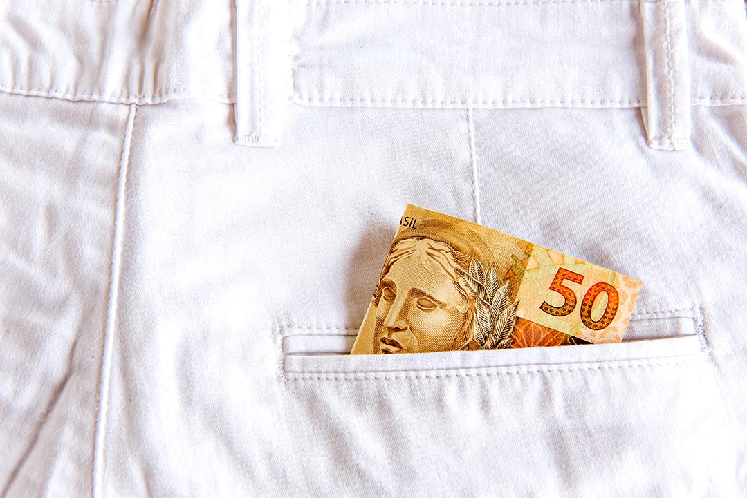 Calça jeans com nota de dinheiro no bolso