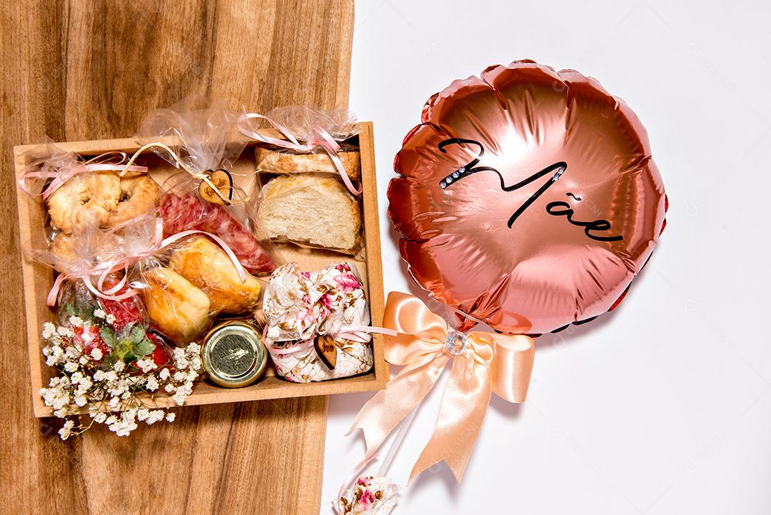 Feliz presente de dia das mães. Caixa com vários itens e balão escrito mãe em português