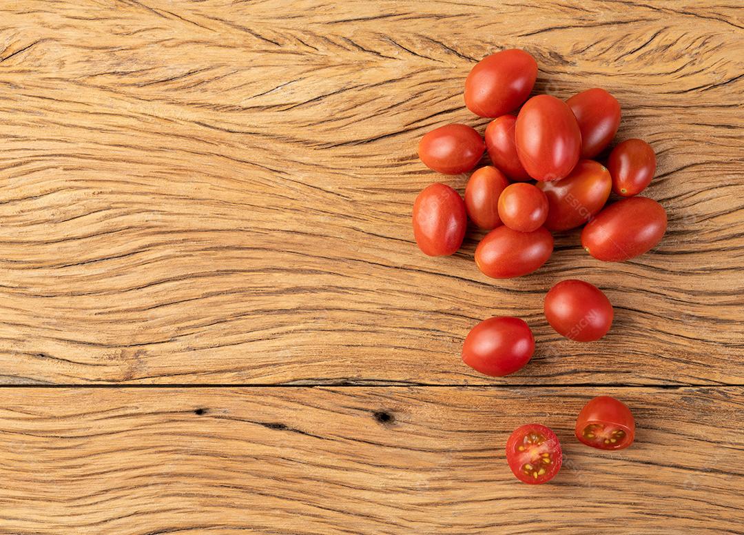 Um grupo de tomate cereja sobre mesa de madeira com espaço de cópia