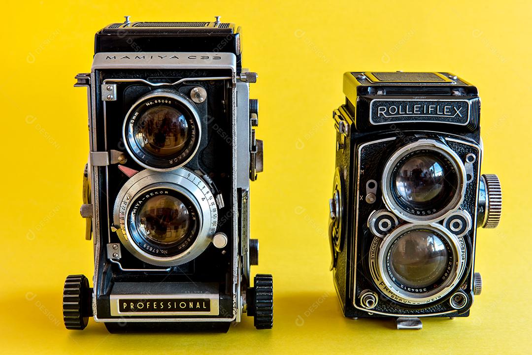 Câmera fotográfica antiga e vintage Minolta em fundo amarelo.